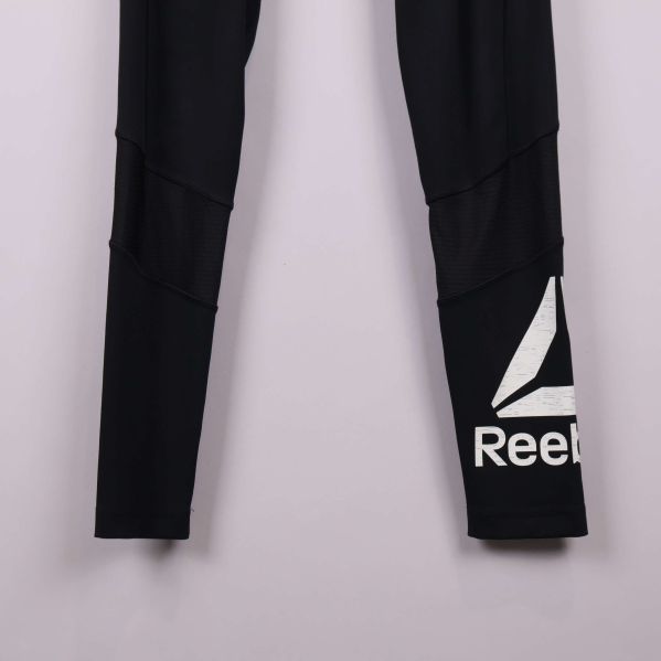 Närbild på Reebok-loggan i vitt på benet