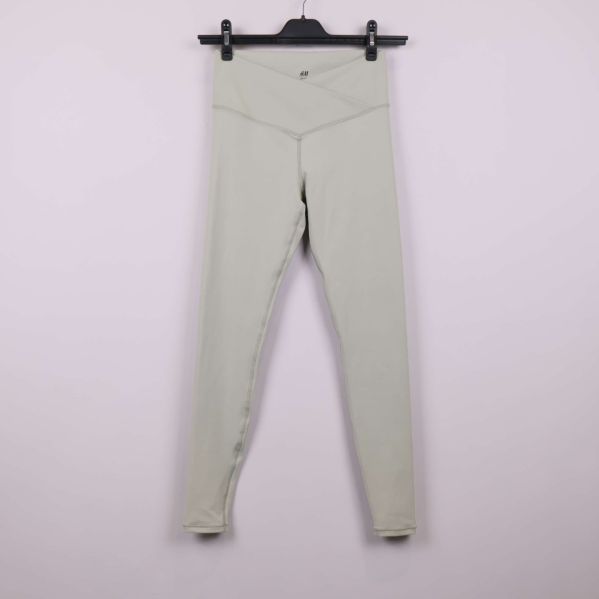 Ljusbeiga leggings framifrån på galge mot ljus bakgrund