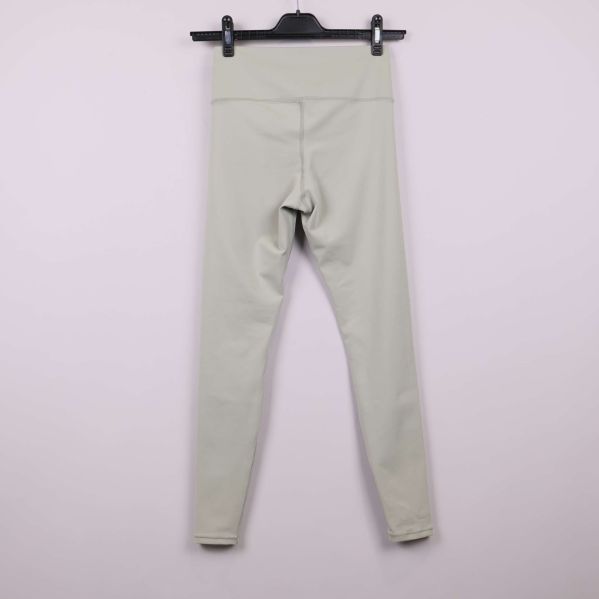 Ljusbeiga leggings bakifrån på galge mot ljus bakgrund