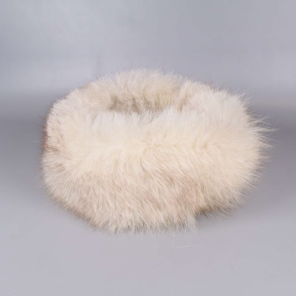 Fluffig cremevit pälskrage liggande på grå bakgrund