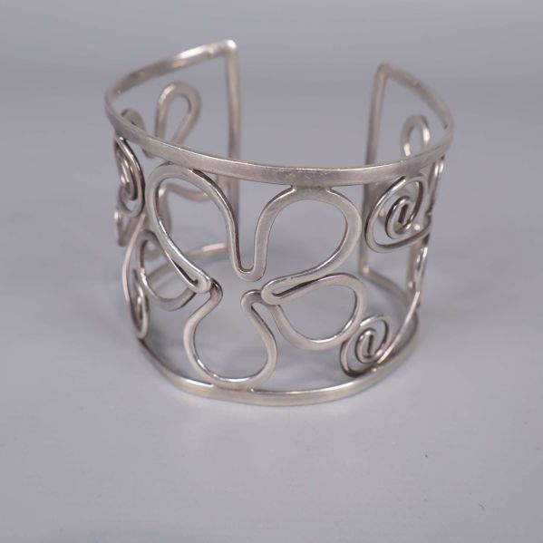 Framifrån vy av armring med blom- och snirkelmönster