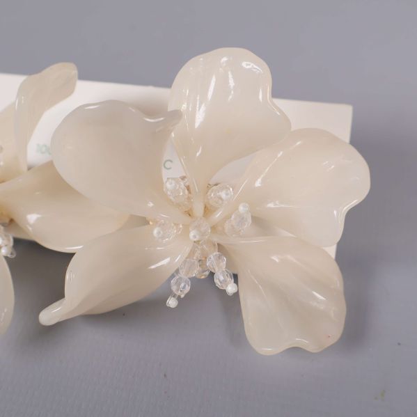 Närbild av det vita blommönstret och glittrande pärlor