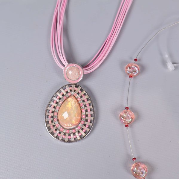 Närbild på rosa halsband med stort pärlhänge