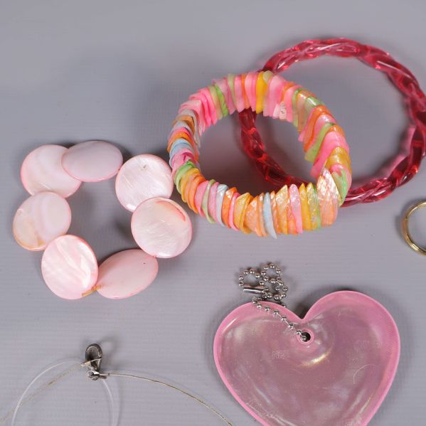 Olika armband i rosa, rött och flerfärgat mönster