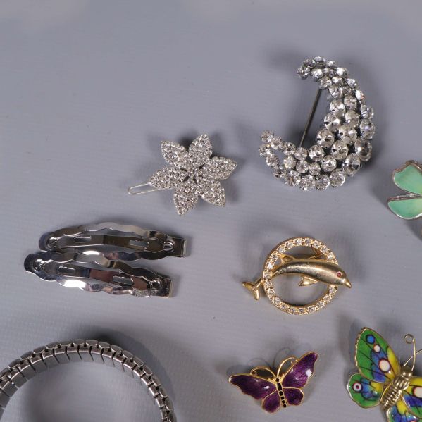 Närbild av glittrigt blomspänne, månbrosch och metallspännen