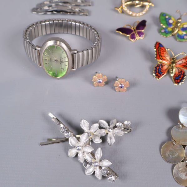 Grönt armbandsur och blommiga hårspännen i silverfärg