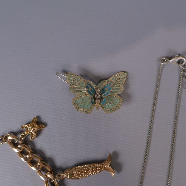 Närbild av brosch formad som fjäril i turkos och guld