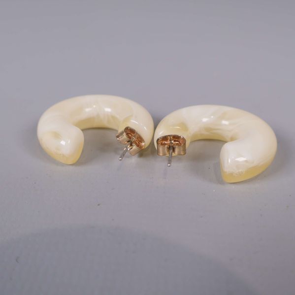 Creolörhängen i plast med metallstift sedda från sidan