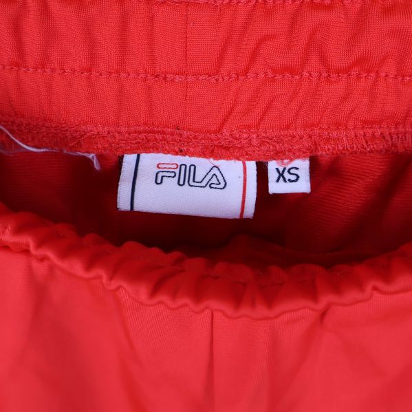 Närbild på FILA-logga och storlekslapp XS i midjan