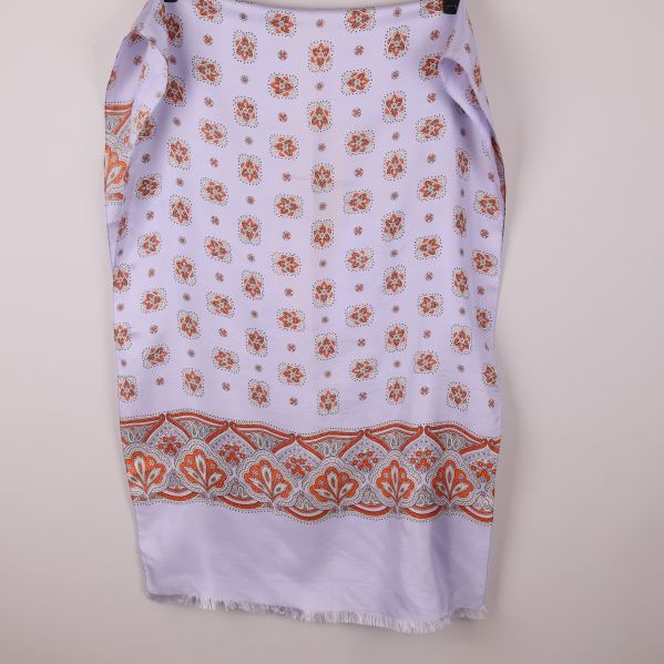 Närbild på sjal med orange bård och blommiga detaljer