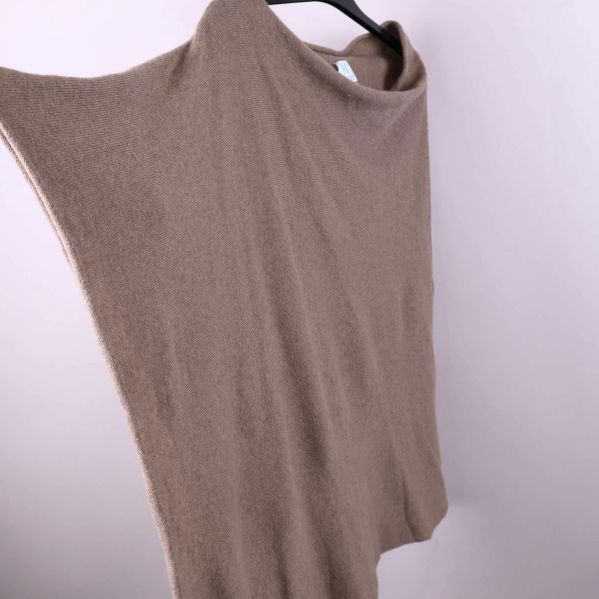 Detaljbild på ponchons stickade tyg och halsringning