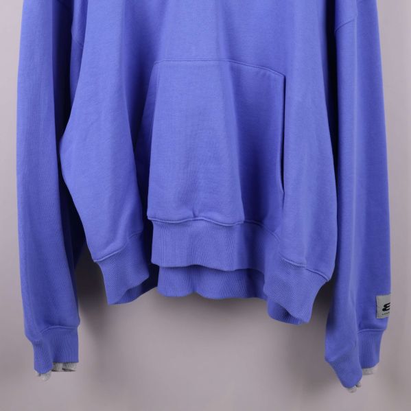 Nederkant och ärmslut på blå hoodie med ribbade muddar