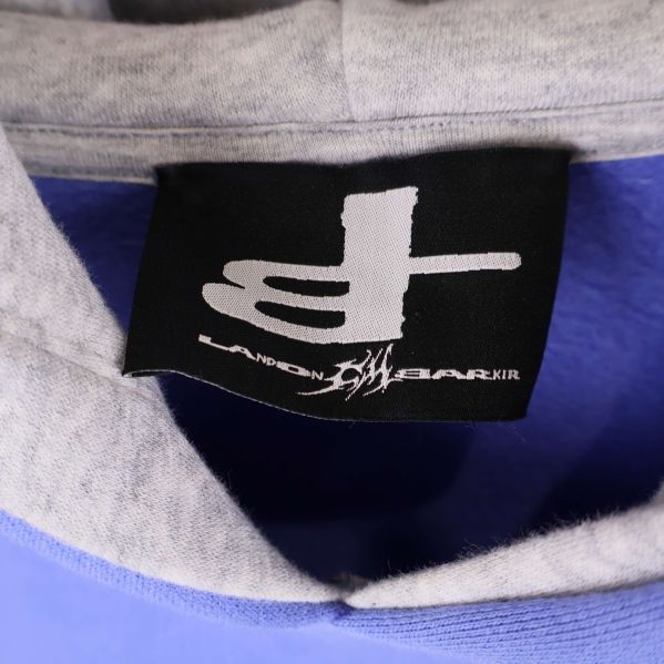 Närbild på svart varumärkestagg med logotyp inuti huvan