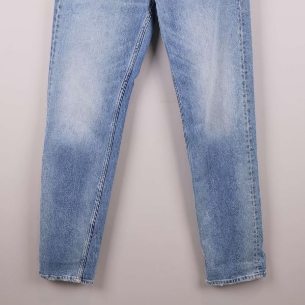 Benpartiet på ljusblå jeans med diskreta slitningar