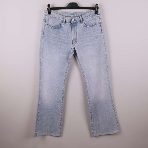 Framsidan av ljusblå raka jeans på galge