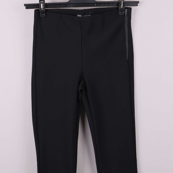 Närbild av övre del på smal svart byxa framifrån