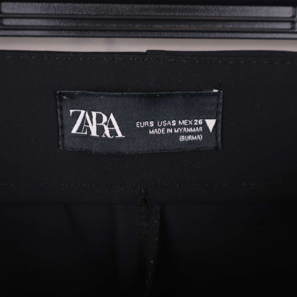 Närbild på ZARA-märke och storlekslapp i linningen