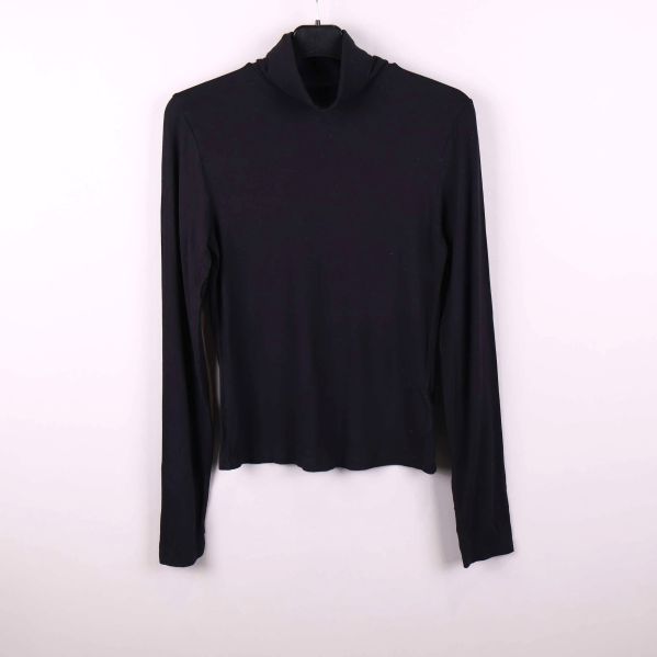 Svart långärmad polotröja hängande mot vit bakgrund