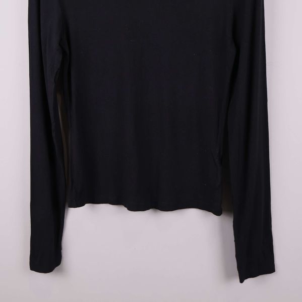 Nedre delen av svart långärmad polotröja