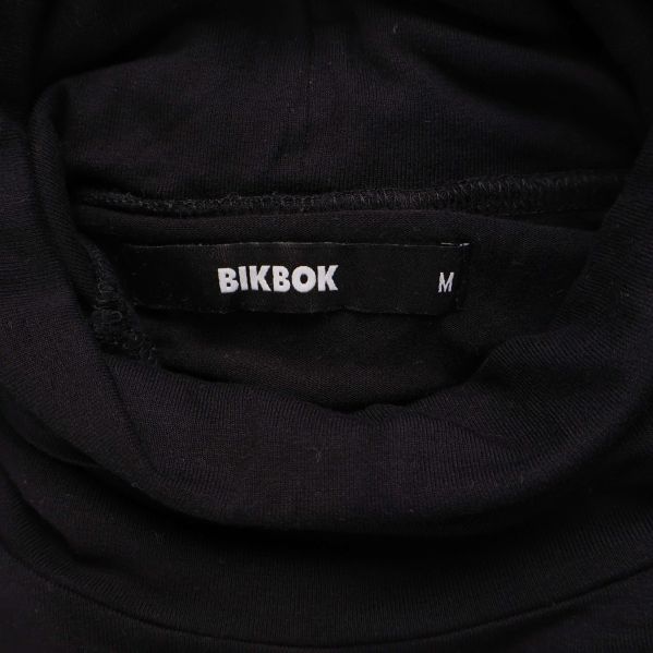 Närbild på etikett med Bik Bok och storlek M