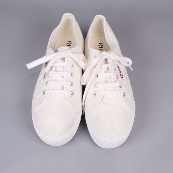 Sneakers sedd uppifrån med vita snören och logotyp