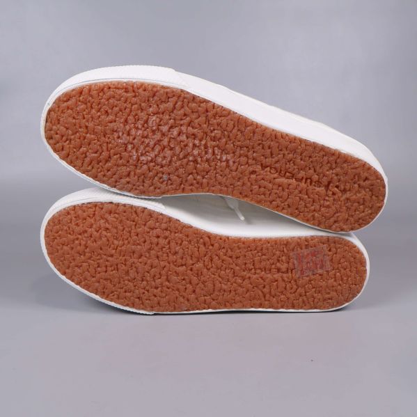 Bruna räfflade yttersulor på vita sneakers