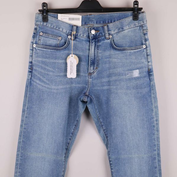 Närbild på jeansens framfickor och linning