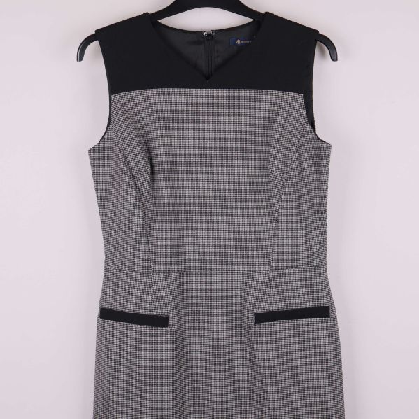 Närbild på överdelen med svarta detaljer och rutigt tyg