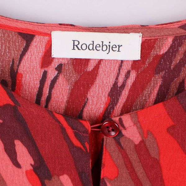Närbild på Rodebjer-logotyp i nacken på blusen