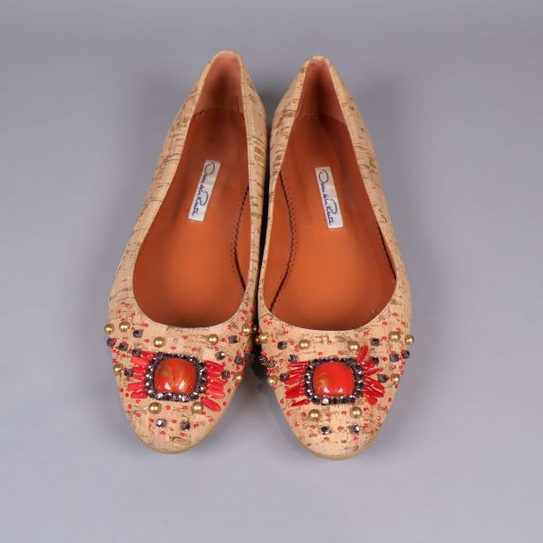 Ballerinaskor med röda och guldiga detaljer sedd ovanifrån