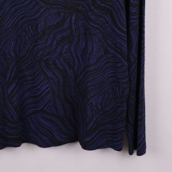 Närbild på nedre del av toppens framsida och ärmslut