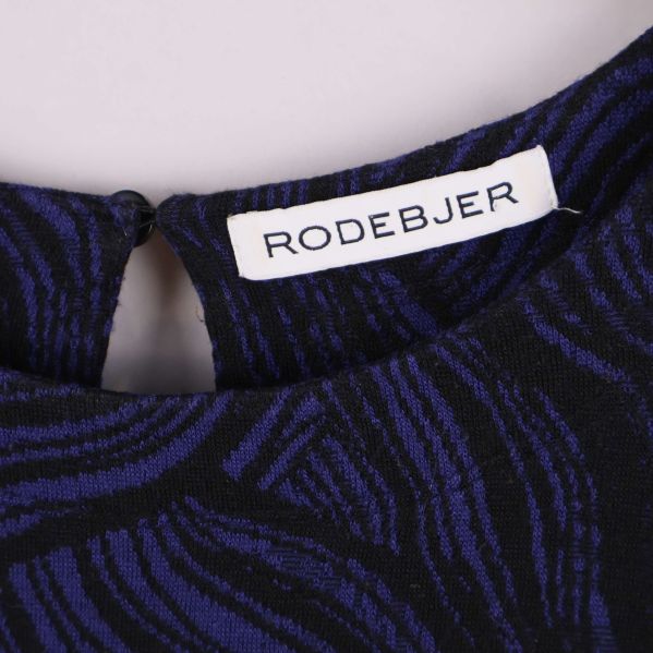 Närbild av Rodebjer etikett vid halsen