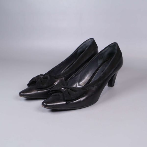 Svarta pumps med klack och rosetter, sned vy