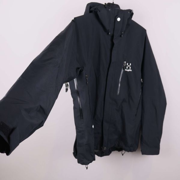 Jacka med utsträckt ärm och dragkedjor i fokus