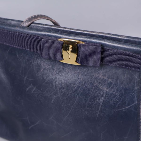 Närbild på väskans rosett och guldfärgat spänne