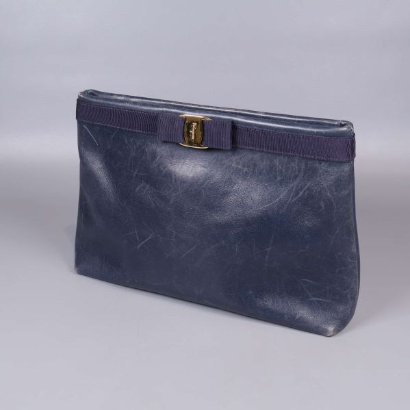 Blå axelväska stående med guldfärgat spänne