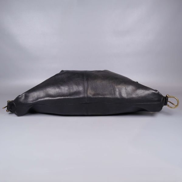 Svart läderväska fotograferad liggande med mässingsspännen