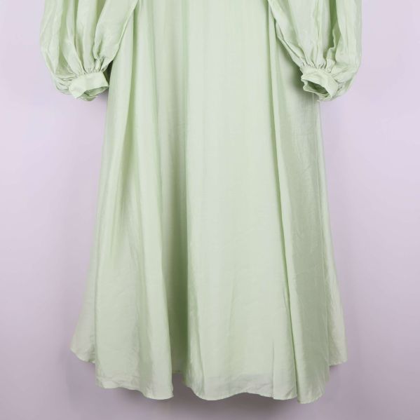 Nederdel av ljusgrön klänning med utsvängd fåll