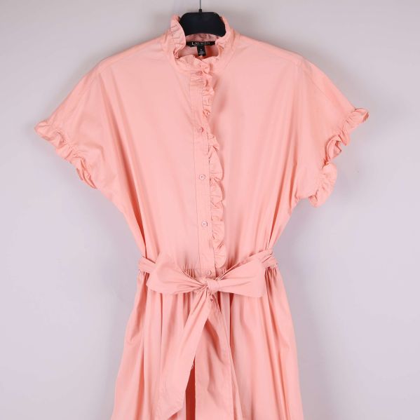 Närbild på klänningens överdel med volang och knappar