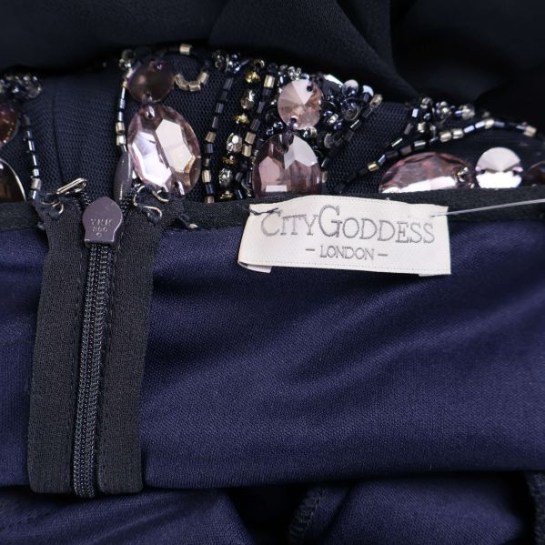 Närbild på City Goddess London-märkeslapp inuti klänningen