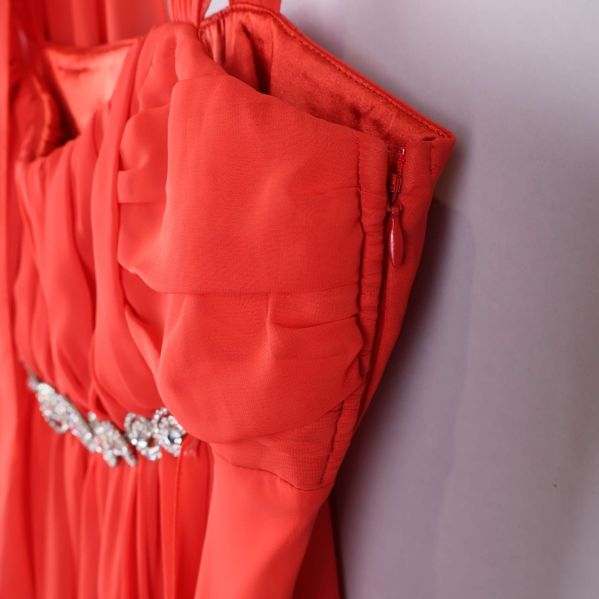 Sidosöm och dragkedja på röd klänning i närbild