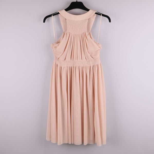 Ljusrosa klänning bakifrån på galge