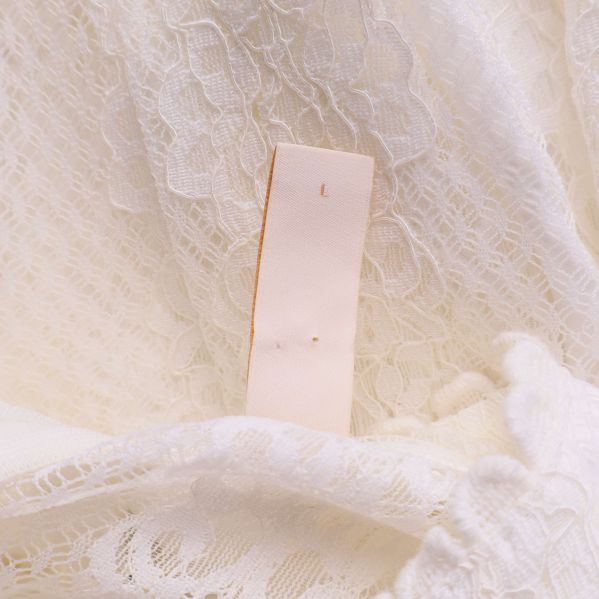 Storlekslapp med bokstaven L i vit spetsklänning