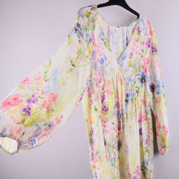 Närbild på klänningens ballongärm och blommiga mönster