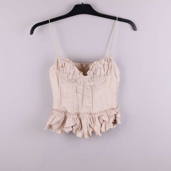 Volangprydd ljusbeige bustier med smala axelband på galge