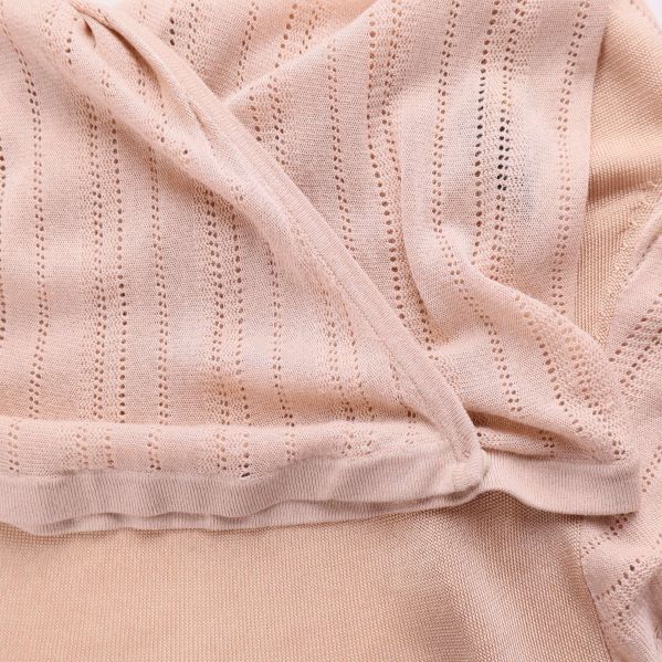 Närbild på strukturerad stickning och tyg vid knuten