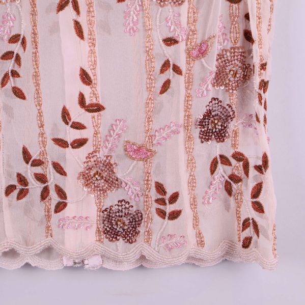 Nederkant av topp med rosa och brunt broderi