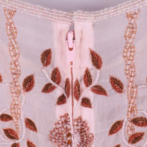 Närbild på dragkedja och broderi i ryggen