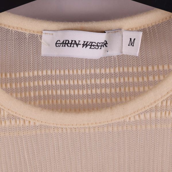 Närbild på etikett med Carin Wester och storlek M