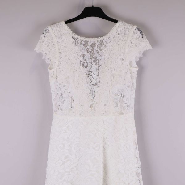 Övre del av vit spetsklänning med spetsdetaljer och kort ärm